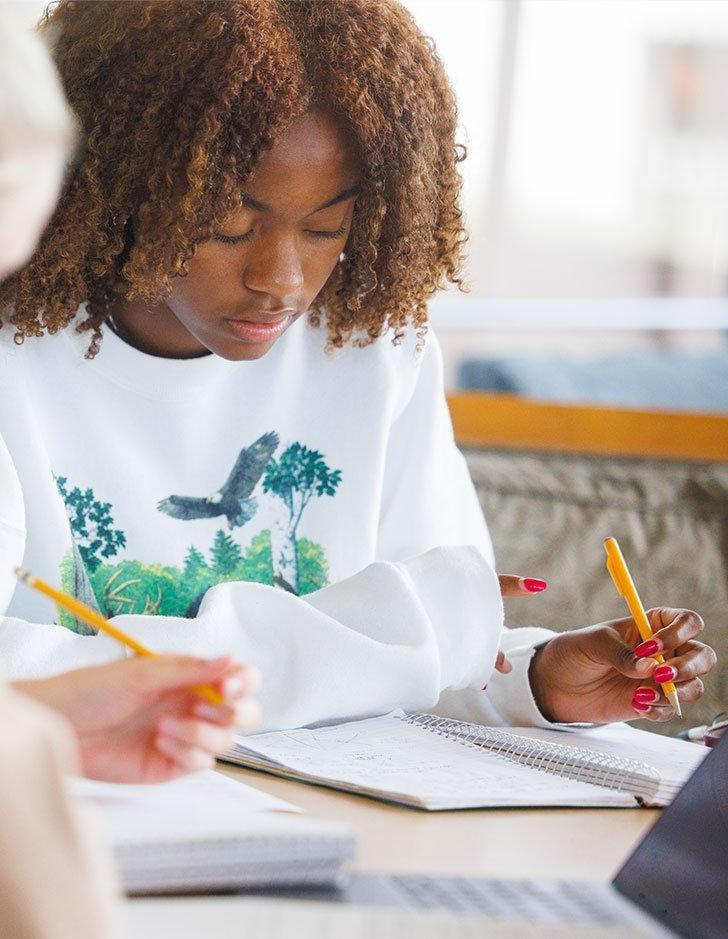 A student writes in a notebook.